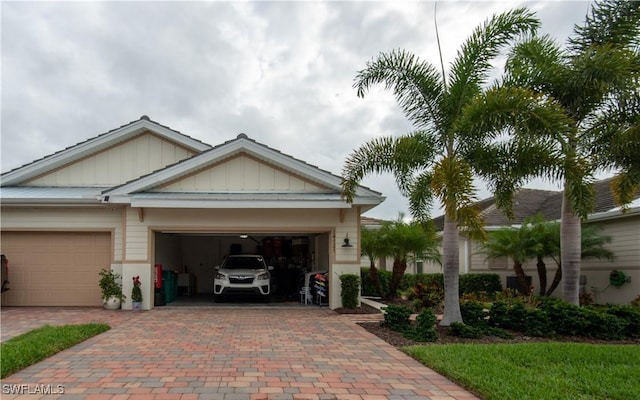 view of front of property with a garage, decorative driveway, and board and batten siding