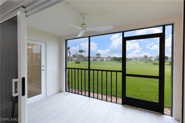 unfurnished sunroom featuring ceiling fan