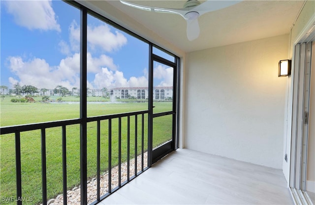 unfurnished sunroom featuring ceiling fan