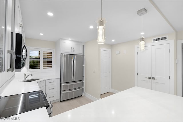 kitchen with black microwave, range with electric cooktop, hanging light fixtures, light countertops, and freestanding refrigerator