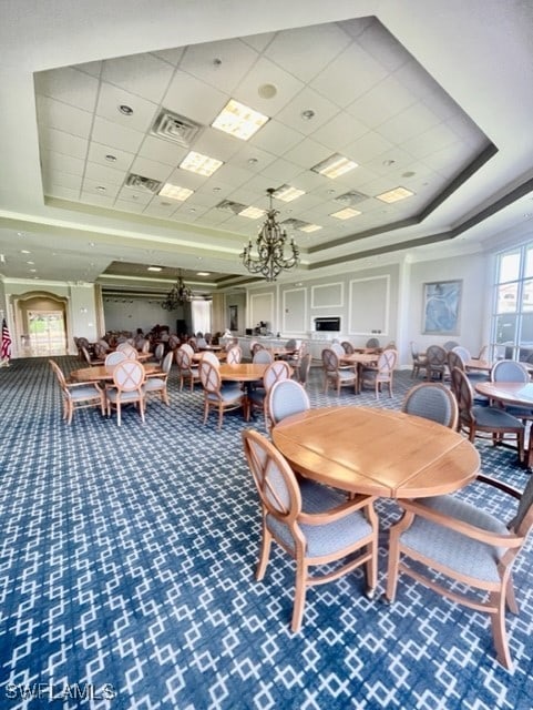 dining area featuring a chandelier, carpet, a raised ceiling, and visible vents