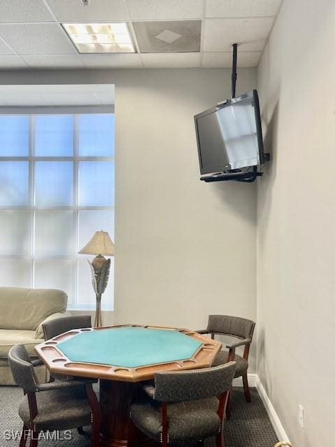 game room with a paneled ceiling, baseboards, and carpet flooring