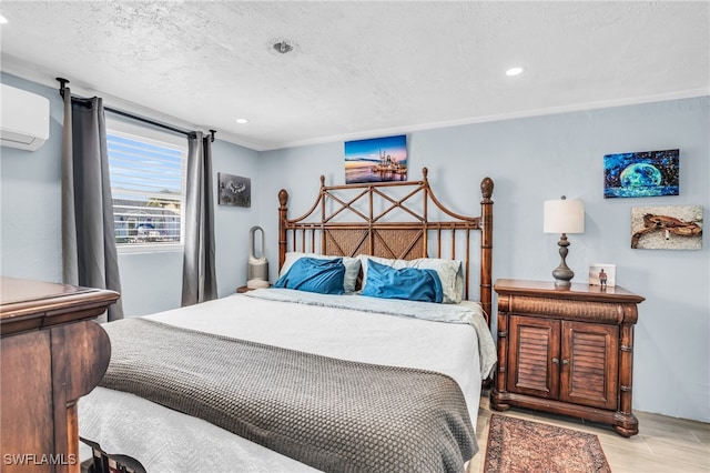 bedroom with a textured ceiling and a wall mounted AC