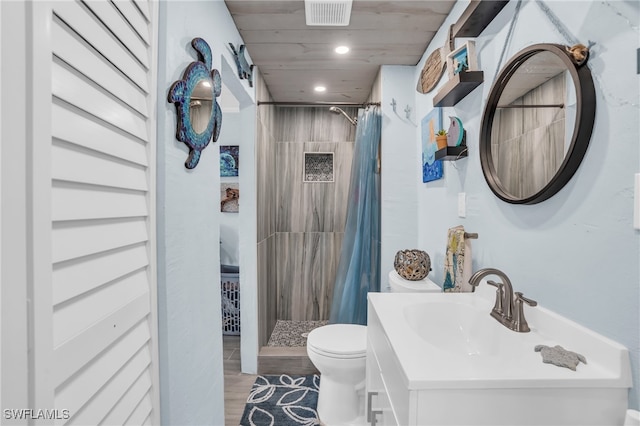 bathroom featuring hardwood / wood-style floors, walk in shower, toilet, and vanity