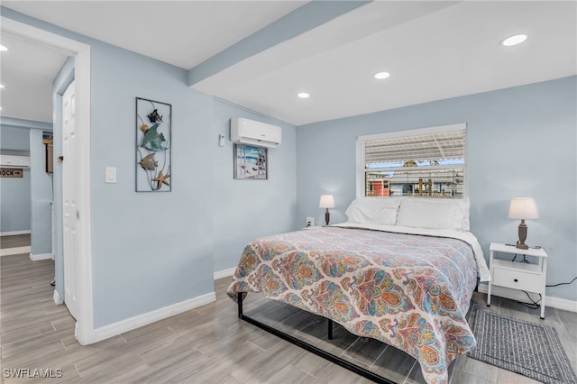 bedroom featuring light wood-type flooring and a wall unit AC