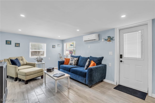 living room with an AC wall unit and light hardwood / wood-style floors