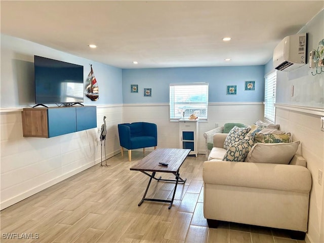 living room featuring recessed lighting, a wainscoted wall, a wall mounted air conditioner, and light wood-type flooring