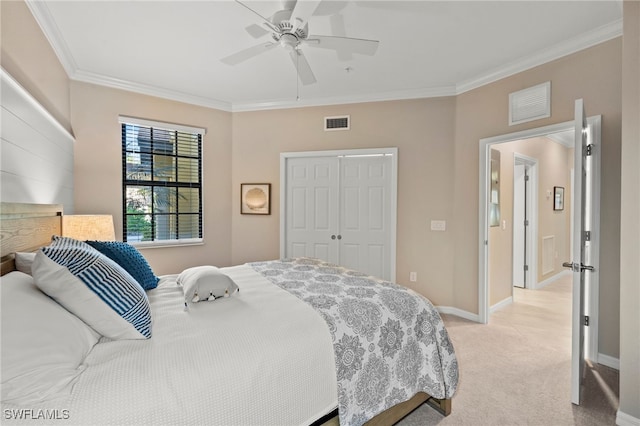 carpeted bedroom with a closet, ceiling fan, and ornamental molding