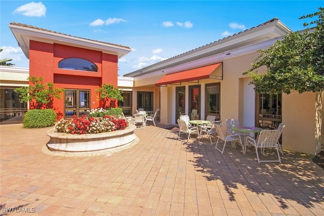 back of house featuring a patio, outdoor dining space, and stucco siding