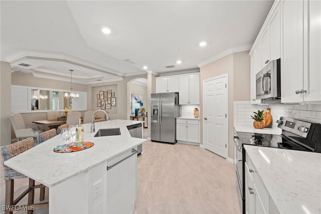 kitchen featuring light stone countertops, an island with sink, appliances with stainless steel finishes, and a breakfast bar area