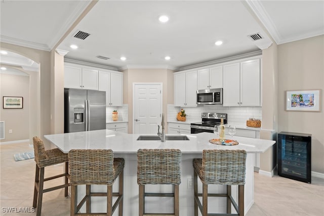 kitchen with white cabinets, a spacious island, sink, appliances with stainless steel finishes, and beverage cooler