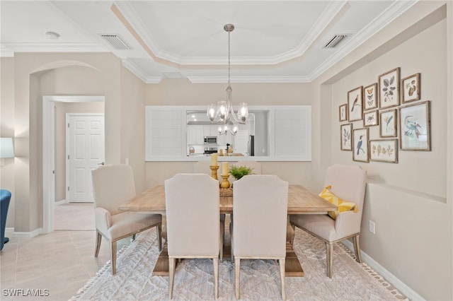 dining space with a raised ceiling, crown molding, and an inviting chandelier