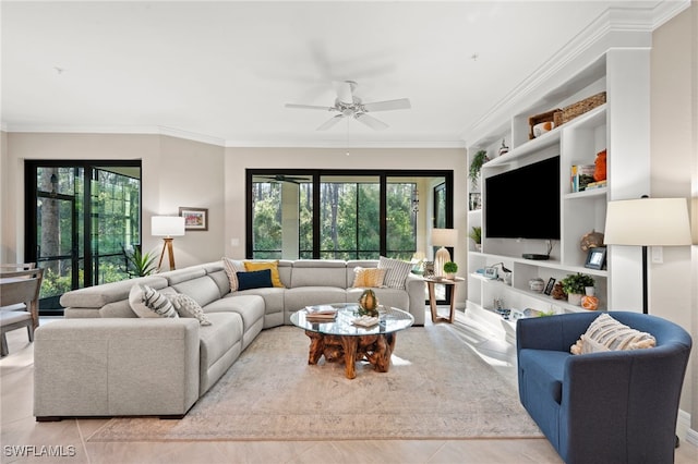 living room with ceiling fan, plenty of natural light, light tile patterned flooring, and ornamental molding