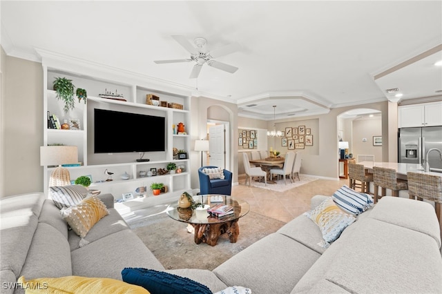 living room with built in features, arched walkways, crown molding, light tile patterned floors, and a ceiling fan