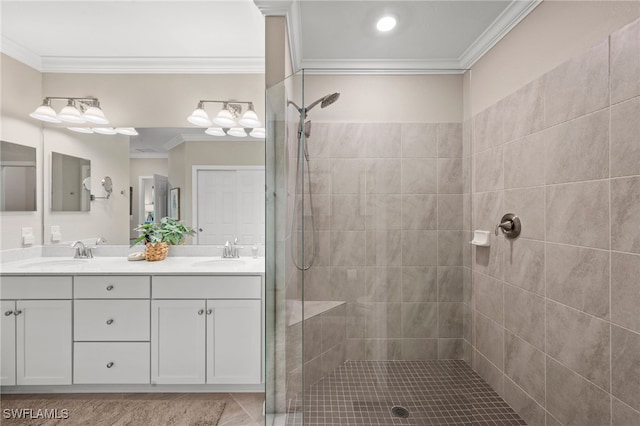 bathroom with vanity, a tile shower, and ornamental molding