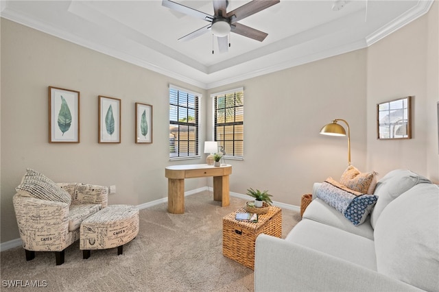 living room with carpet, ceiling fan, crown molding, and a tray ceiling