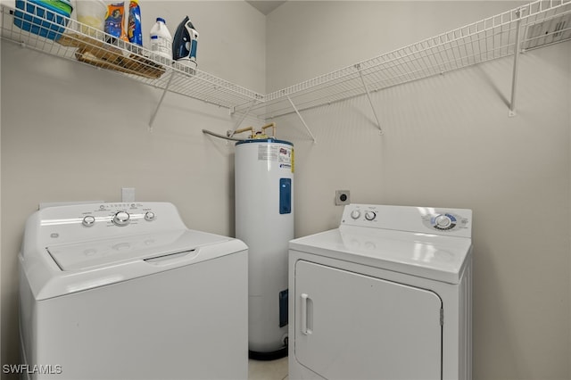 clothes washing area with laundry area, washing machine and dryer, and electric water heater