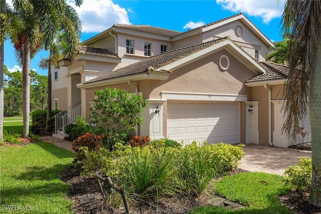 mediterranean / spanish-style house featuring a garage and a front yard