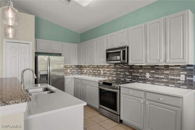 kitchen featuring appliances with stainless steel finishes, a kitchen island with sink, hanging light fixtures, sink, and lofted ceiling