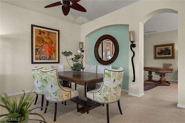 dining room with light carpet, baseboards, and a ceiling fan