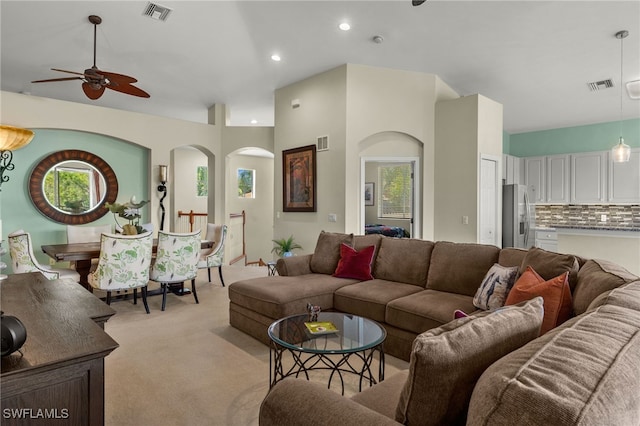 living room featuring visible vents, a ceiling fan, and light colored carpet