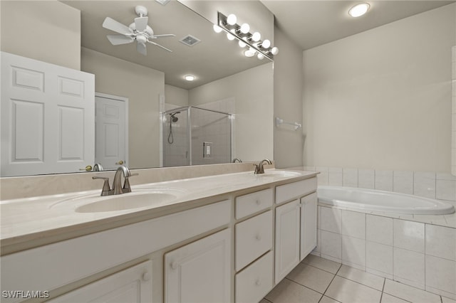 full bathroom with double vanity, tile patterned flooring, a shower stall, and a sink