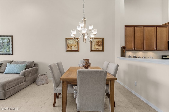 dining space with an inviting chandelier, a high ceiling, and light tile patterned flooring