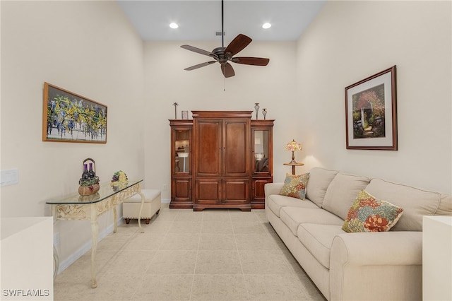 living room with a towering ceiling and ceiling fan