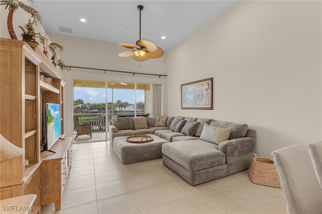 living room featuring ceiling fan, light tile patterned floors, and high vaulted ceiling