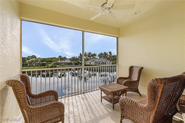 sunroom / solarium featuring a water view and ceiling fan