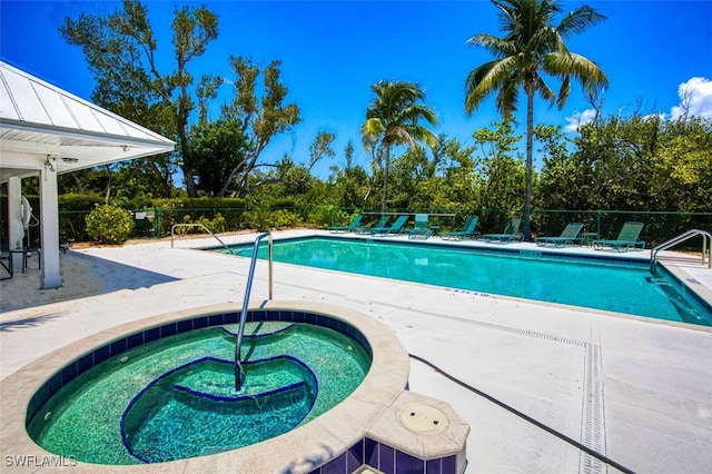 community pool featuring a community hot tub, a patio, and fence