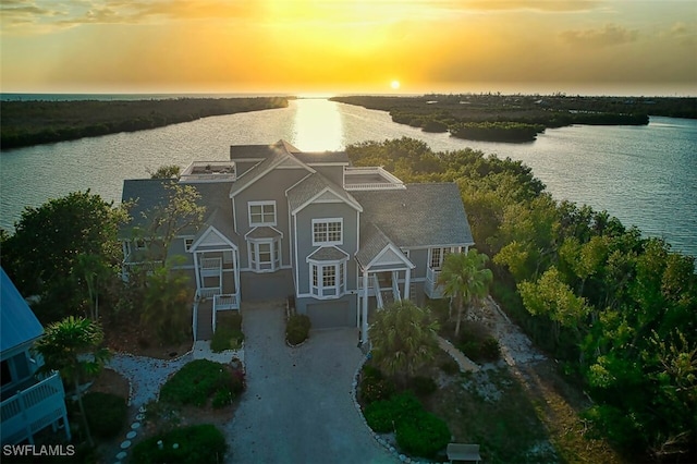 aerial view at dusk featuring a water view