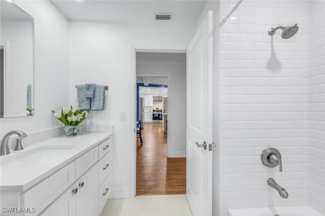 bathroom featuring vanity, tile patterned flooring, and tiled shower / bath combo