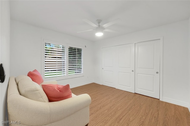 living area featuring hardwood / wood-style flooring and ceiling fan