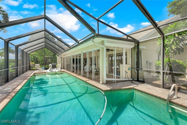 view of swimming pool featuring ceiling fan, a lanai, and a patio area