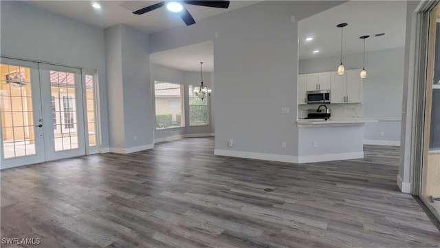 6733 Bent Grass Dr, Naples, FL 34113 - unfurnished living room with french doors, dark wood-style flooring, ceiling fan with notable chandelier, and baseboards