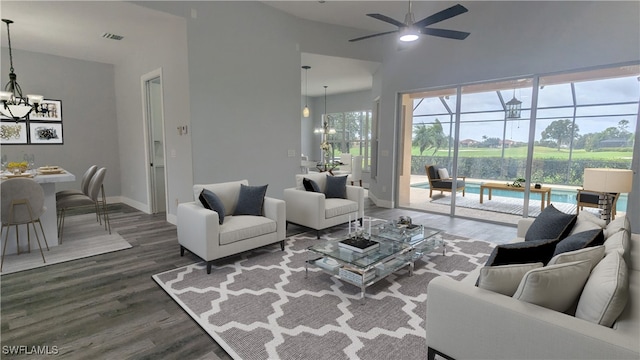 living room featuring ceiling fan with notable chandelier and dark hardwood / wood-style flooring