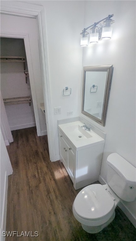 bathroom featuring wood-type flooring, toilet, and vanity