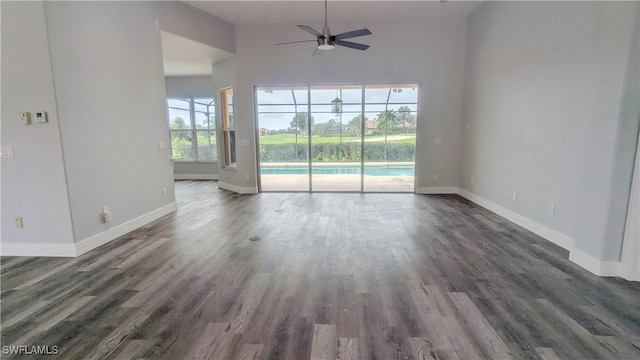 unfurnished room with dark wood-type flooring, high vaulted ceiling, plenty of natural light, and ceiling fan