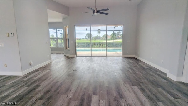 6733 Bent Grass Dr, Naples, FL 34113 - unfurnished living room featuring baseboards, dark wood-style floors, and ceiling fan