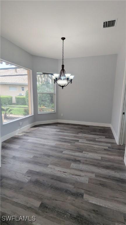 6733 Bent Grass Dr, Naples, FL 34113 - interior space featuring baseboards, a notable chandelier, and wood finished floors