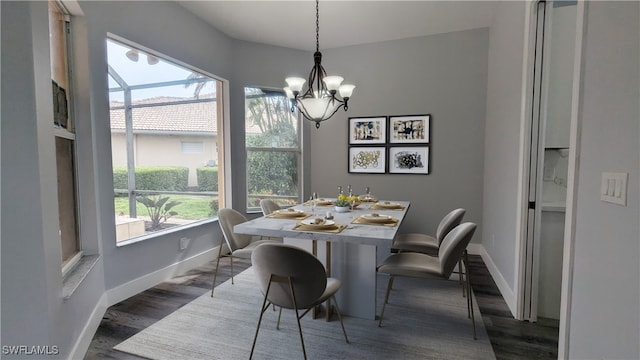 dining space featuring hardwood / wood-style flooring and an inviting chandelier