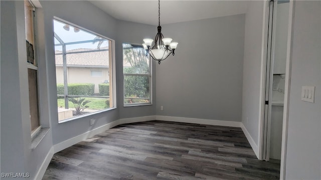 unfurnished dining area featuring dark hardwood / wood-style flooring and a notable chandelier