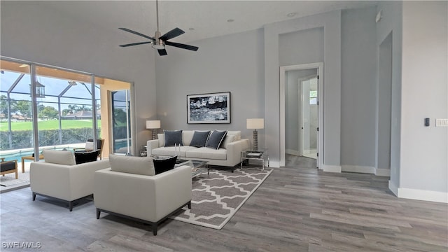 living room featuring ceiling fan, hardwood / wood-style floors, and high vaulted ceiling