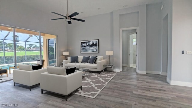 6733 Bent Grass Dr, Naples, FL 34113 - living area featuring a high ceiling, wood finished floors, a sunroom, baseboards, and ceiling fan