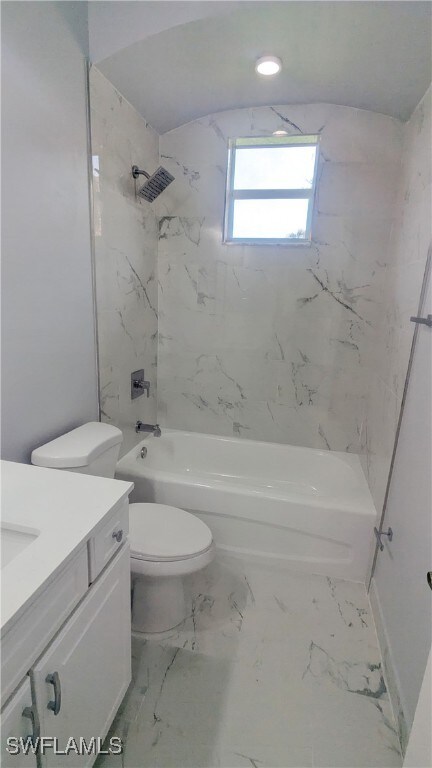 full bathroom with toilet, tiled shower / bath combo, and vanity