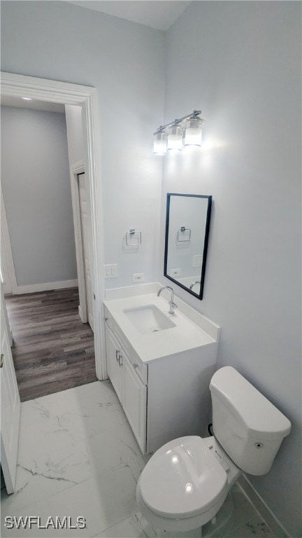 bathroom featuring vanity, toilet, and hardwood / wood-style floors