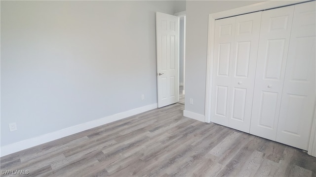 unfurnished bedroom with a closet and light hardwood / wood-style floors