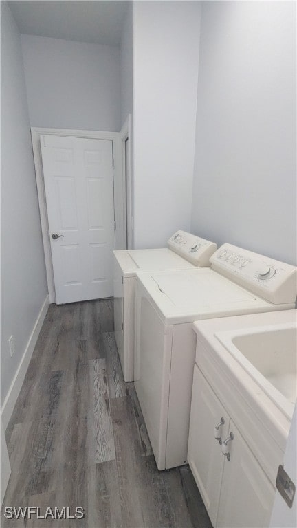 laundry area featuring separate washer and dryer, dark hardwood / wood-style flooring, and cabinets