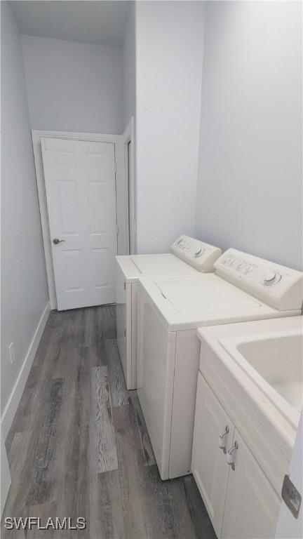 6733 Bent Grass Dr, Naples, FL 34113 - washroom featuring baseboards, washing machine and clothes dryer, cabinet space, and dark wood-type flooring